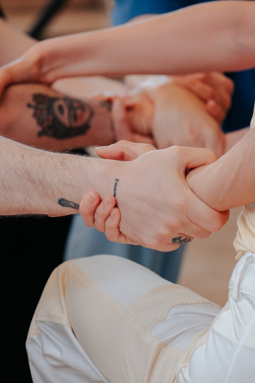 close up of a group of people holding hands